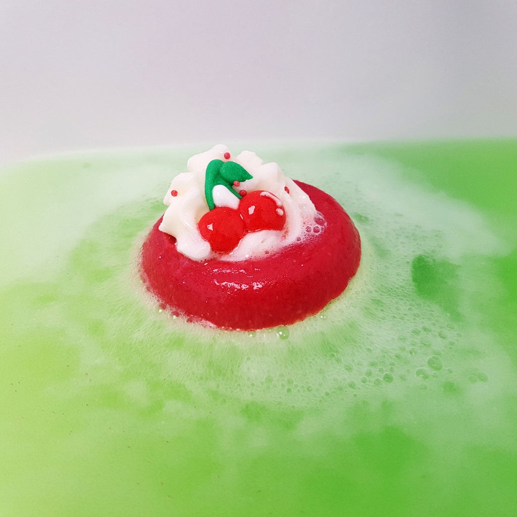 Cherry On Top Bath Blaster fizzing, releasing its green hue into the water